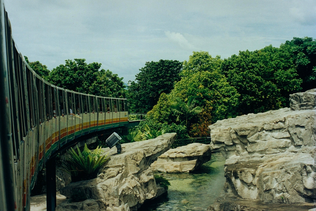 Zug der SDC Sentosa Monorail am 08.Mai 2002 zwischen der Cable Car Station 4 und der Central Beach Station 5 am Fuße des Merlion. An der selber Stelle verläuft heute die Trasse des Sentosa Express. (Fotoscan)
