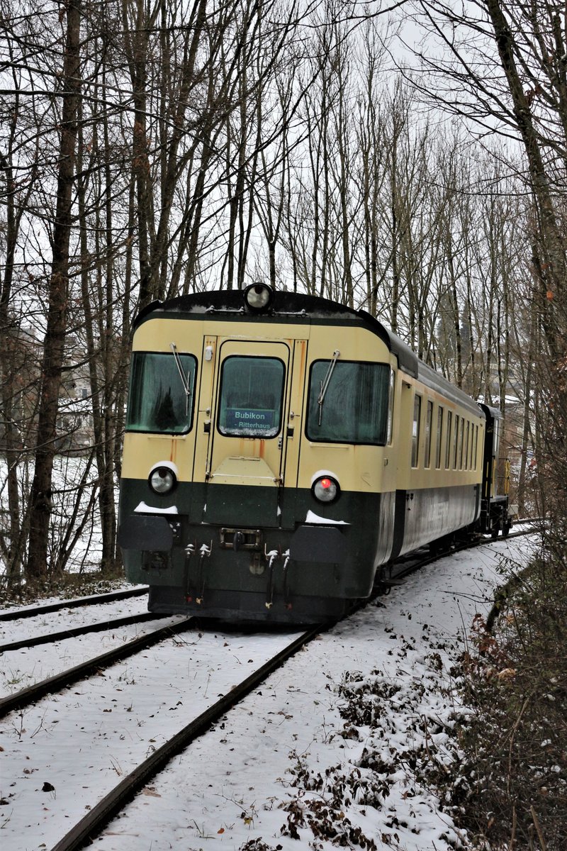 Zug  Wolfhuuser-Bahn : ABt 50 48 39-35 154-2 ex SOB und DSF Tm 2/2 II Nr. 111 ex AVO mit einem kleinem Gepäckwaggon, anlässlich der Zubringerfahrten an den Weihnachtsmarkt im Ritterhaus Bubikon (Hintergrund), auf einem kurvigem Streckenabschnitt zwischen Wolfhausen und Bubikon. Die Strecke war Teil des Schienennetzes der ehemaligen Uerikon-Bauma-Bahn, die heute nur für Draisinenfahrten oder sonst für Extrafahrten, eingesetzt werden. Sonntag, 10. Dezember 2017