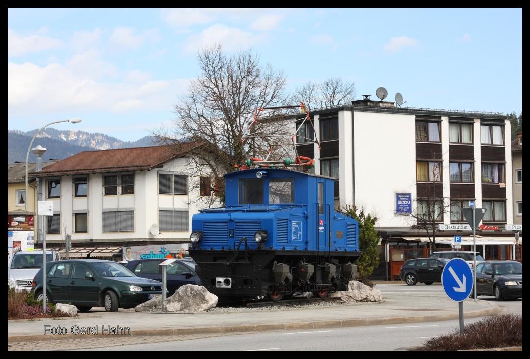 Zugspitzbahn Tal Lok 2 steht heute mitten in der Stadt Garmisch - Partenkirchen an der belebten Kreuzung Bahnhofstraße / Hauptstraße und erregt dort die Aufmerksamkeit der Touristen. Aufnahme am 24.03.2015.
Ich kann mich noch erinnern, dass die Lok zunächst einige Jahre nahe der Endstation der Zugspitzbahn als Denkmal auf einem Parkplatz am Bahnhof in Garmisch - Partenkirchen stand. Da gefällt mir der heutige Standort weitaus besser.
