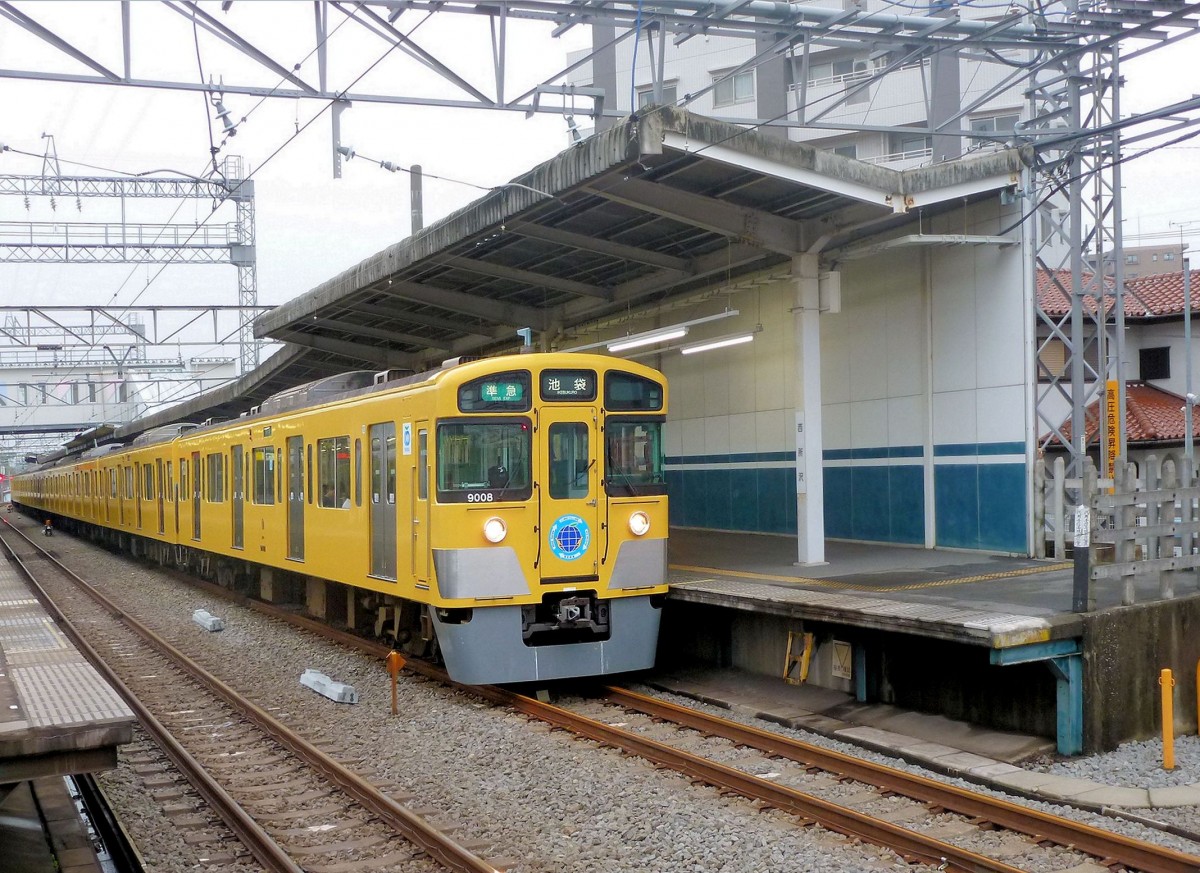 Zum Seibu-Konzern: Im Gegensatz zu den heutigen JR bzw. der alten Staatsbahn, welche den S-Bahnverkehr im wesentlichen auf den grossen nationalen Hauptachsen betreiben, liegt der öffentliche Verkehr in die verschiedenen Bezirke und Vororte der riesigen japanischen Bevölkerungszentren grundsätzlich in der Hand von Grosskonzernen mit ihrem engmaschigen Bus- und Schienennetz. Der Seibu-Konzern mit knapp 4000 Mitarbeitern betreibt unter anderem ein dichtes Eisenbahnnetz (1067 mm-Spur) von 173,8 km von Tokyo aus Richtung Nordwesten; die längste Strecke ist 76,8 km lang, die kürzeste gerade mal 1,0 km. Das Seibu-Angebot (Fahrzeuge, Fahrplan) war ganz im Gegensatz zur alten Staatsbahn stets innovativ und bequem, so dass Mitarbeiter und Manager der grossen japanischen Unternehmen sich gerne im Umfeld von Seibu-Dienstleistungen niederliessen. Die beiden Schriftzeichen  Sei  (Aussprache wie English  say ) –  bu  bedeuten  Westen  und  Musashino  (alter Provinzname für das Gebiet westlich von Tokyo), zusammen also  (Bahnen in) West-Musashino . Im Bild steht der Zehnwagenzug 9008 - ein typischer gelber Seibu-Zug, der in Seibu-eigener Fabrikation gebaut wurde – in Nishi Tokorozawa nordwestlich von Tokyo, 22.Oktober 2011.