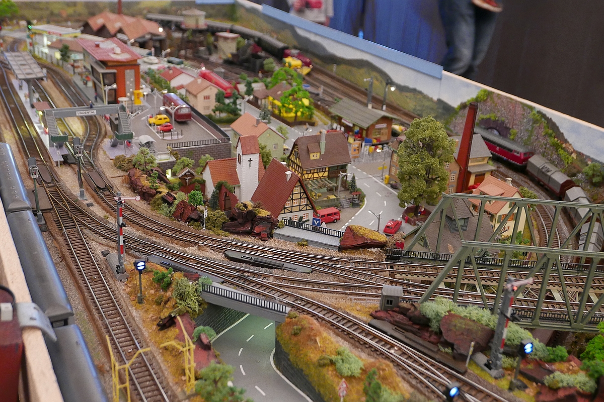 Zum  Tag der Modelleisenbahn  (02.12.) einige Bilder von der mobilen, zusammenklappbaren H0-Anlage von Freund Uli, die im Oktober 2016 bei den Modellbahntagen der Modelleisenbahnfreunde Markdorf im Rahmen des Programms  Raus aus dem Keller  ausgestellt wurde.

Nach dem Bahnhof überqueren die Gleise die Hauptstraße von Lindental und kreuzen kurz danach die Strecke, die nach der Brücke durch einen Tunnel in den Untergrund führt.