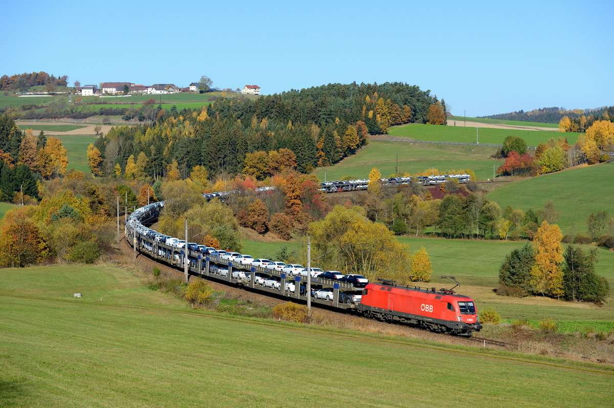Zur regelmäßigen Institution sind die Neuwagen-Transporte über die Summerauer Bahn in Richtung Linz geworden. Das Ladegut verrät den ungewöhnlichen Laufweg des abgelichteten Zuges. Die VW Passat wurden im Werk Emden produziert und nahmen den Weg über Ostdeutschland und die Tschechische Republik nach Österreich. Am Waldburgen Bogen bei Freistadt konnte ich am 31. Oktober 2015 den fotogenen ATGZ 47491 nach Jesenice bei herrlichem Herbstwetter fotografieren, Zuglok war 1116.175.