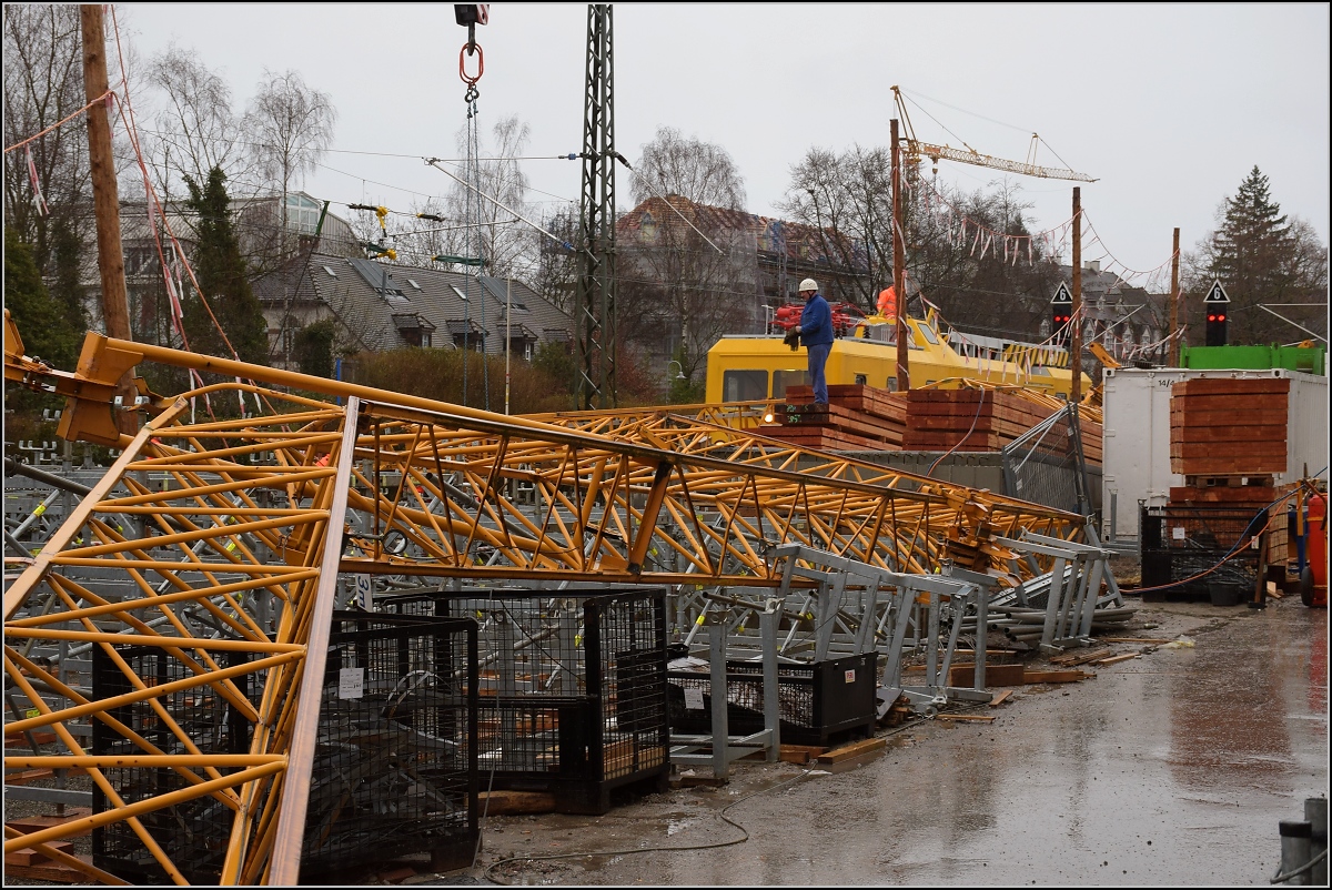 Zusammengefaltet ist der auf das Gleis umgestürzte Kran in Petershausen. Konstanz, Februar 2017.

Standort des Fotografen auf dem Restweg hinter der Baustellenabsperrung.