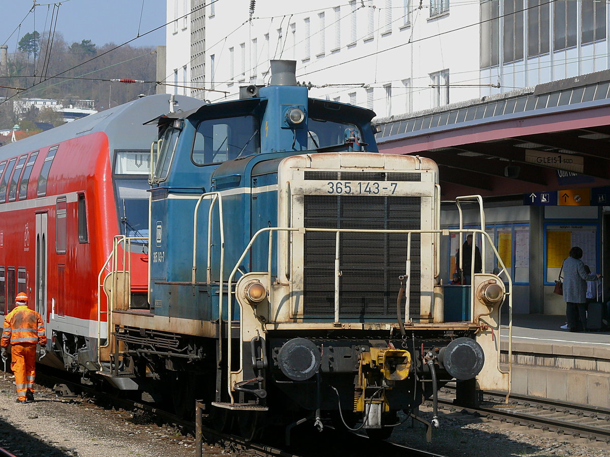 Zusehen ist 365 143 die am 15.04.2019 um 15:03 Uhr zwei Dostos mit  VFB-Fanzug -Schilderung von einem PbZ abholt. Vor dem PbZ hängt 120 127. 