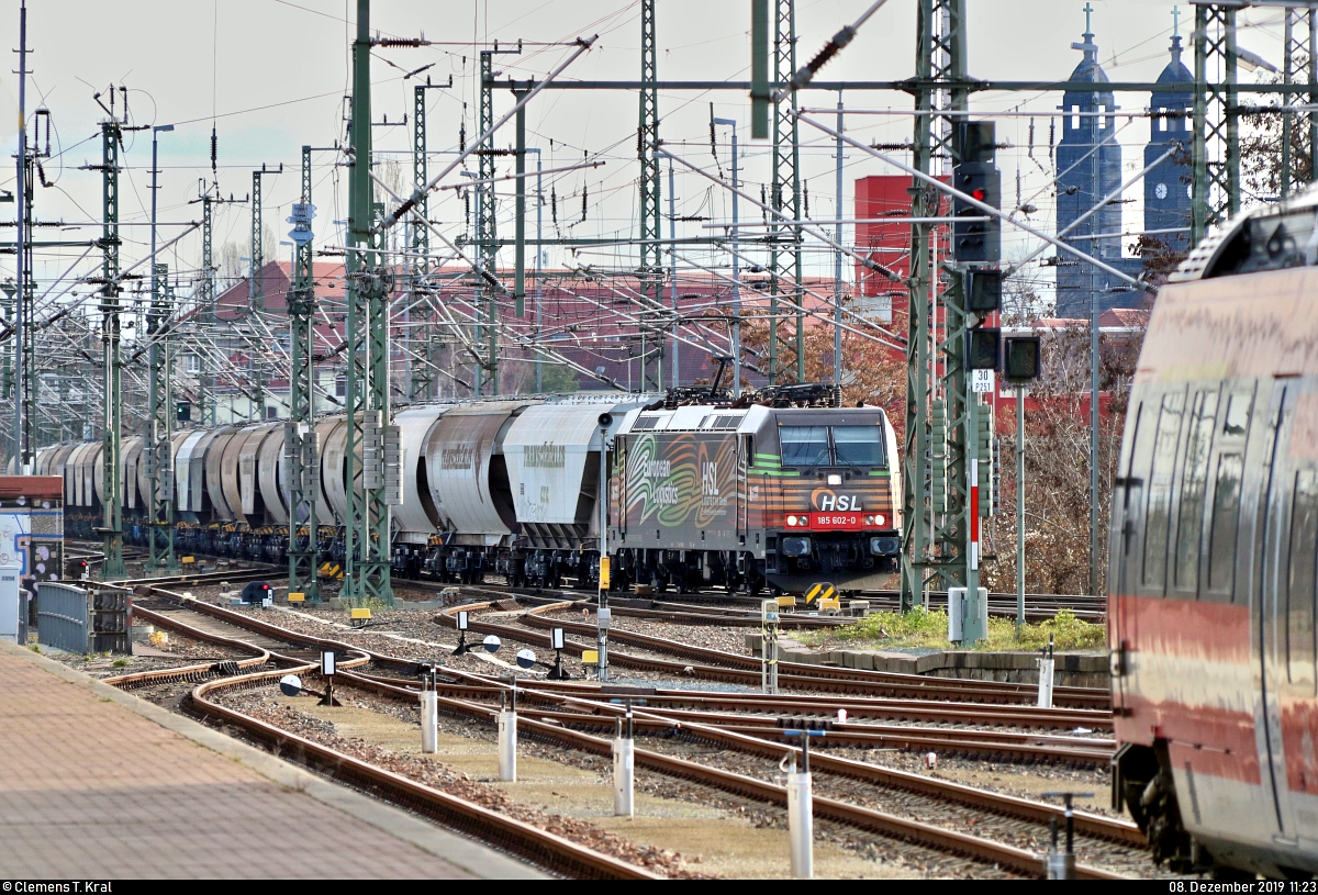 Zwar nicht so geplant, aber meiner Ansicht nach doch zeigenswert:
Auf diesem  Schnellschuss  aus der Tele-Perspektive durchfährt ein Getreidezug (Transcereales) mit 185 602-0 der Beacon Rail Leasing Limited, vermietet an die HSL Logistik GmbH (HSL), Dresden Hbf in westlicher Richtung.
Die Lok wurde dabei zufällig zwischen zwei Masten haargenau eingepasst. Im Hintergrund erheben sich die beiden Türme der Christuskirche Dresden-Strehlen.
Aufgenommen von Bahnsteig 4.
[8.12.2019 | 11:23 Uhr]