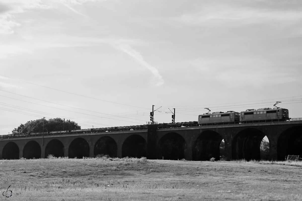 Zwei 151er-Elektrolokomotiven (151 086-6 und ?) ziehen in Doppeltraktion einen Brammenzug über die Duisburg-Hochfelder-Eisenbahnbrücke. (August 2022)