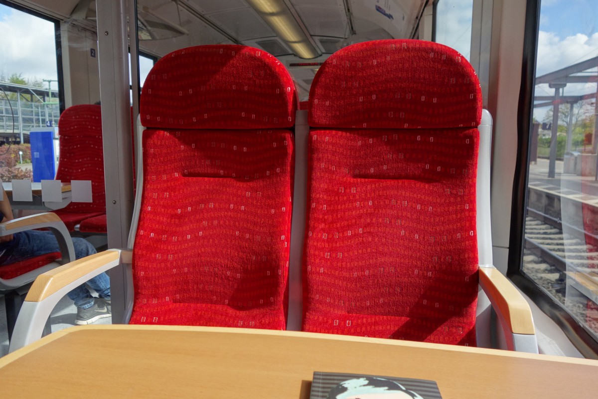 Zwei 1.Klasse-Sitze in der NBE 82184 von Bad Oldesloe nach Neumünster, Mai 2015. Der Unterschied zur 2.Klasse ist in den LINT-Zügen der Nordbahn alleinig im Vorhandensein eines Tisches und der Abtrennung zur 2.Klasse zu finden.