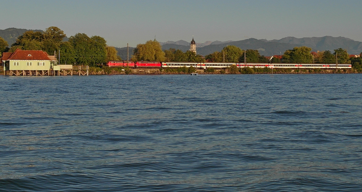 Zwei 218er haben in Lindau den von Zrich kommenden EC 197 bernommen und ziehen diesen am 24.06.2015 kurz nach der Abfahrt in Lindau Hbf ber den Bodenseedamm nach Mnchen.