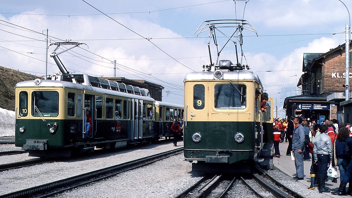 Zwei ABDhe 4/4 der Wengernalpbahn im Bahnhof Kleine Scheidegg Anfang Mai 1981. Die unterschiedlichen Fronten und Stromabnehmer der ersten (rechts) und zweiten (links) Bauserie sind gut erkennbar. Nach Wegfall der 1. Klasse im Jahr 1982 verkehren die Triebwagen als BDhe.