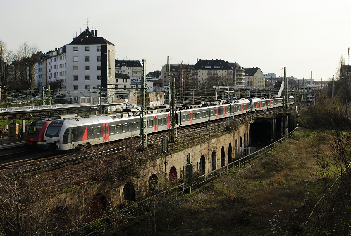 Zwei Abellio-ET 25 von Düsseldorf Hbf. nach Arnhem Centraal passieren am 18.12.2018 den S-Bahn-Haltepunkt Düsseldorf Wehrhahn. In der Mitte die frühere Trasse, die den Güterbahnhof Derendorf mit der Güterumgehungsbahn nach Düsseldorf-Lierenfeld verband, rechts das ehemalige Gelände des Ortsgüterbahnhofes.