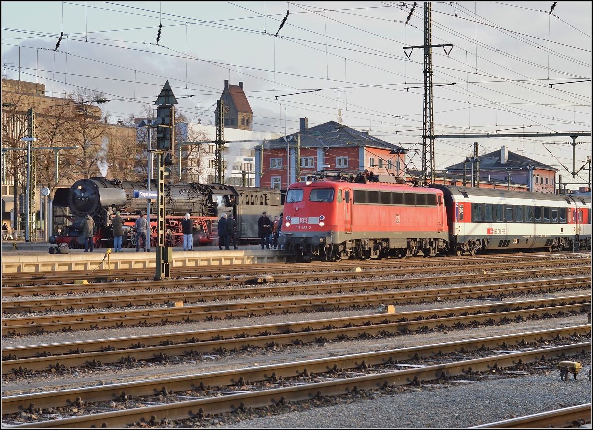 Zwei Edelrenner vergangener Tage, die bis ins hohe Alter mit vollem Einsatz dabei sind. 115 383-2 fährt kurz vor dem Gottharddampfzug mit IC 284 ab. Singen, März 2015. 