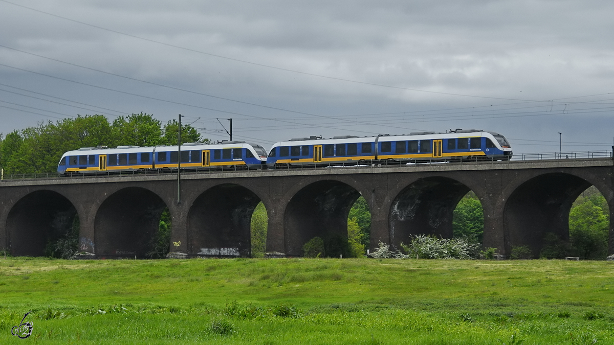 Zwei gekoppelte Dieseltriebzüge der NordWestBahn befahren Anfang Mai 2021 die Hochfelder Eisenbahnbrücke in Duisburg.