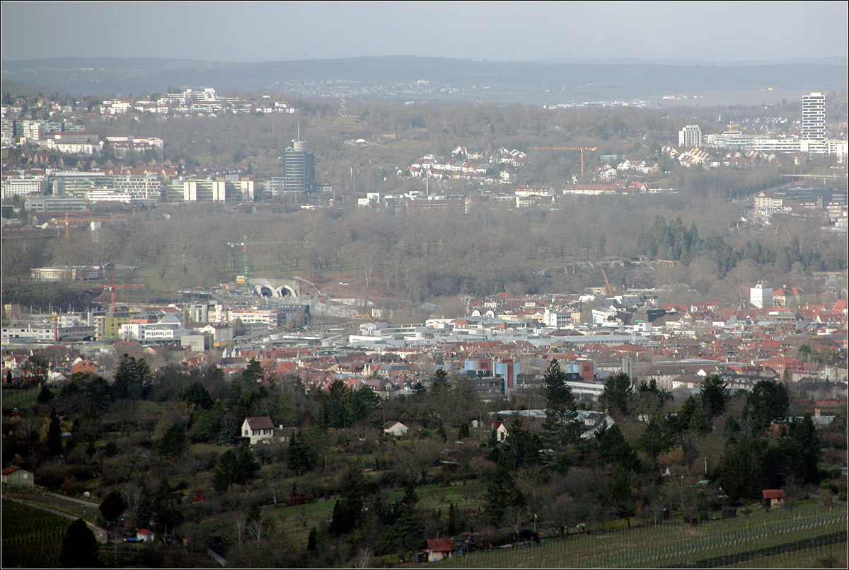 Zwei neue Tunnelportale -

... in der Stadtlandschaft. Blick vom Fellbach Kappelberg auf Bad Cannstatt und die beiden neuen Tunnelportale am Hang des Neckartales. Darüber zieht sich quer durch das Bild der Rosensteinpark mit dem Schloss auf der linken Seite. Darüber die Bürogebäude an der Löwentorbrücke und noch weiter oben im Bild der Killesberg. Das Hochhaus am rechten Bildrand befindet sich auf dem Pragsattel. 

Der linke Tunnel führt zum neuen Stuttgarter Hauptbahnhof und wird dem Regional- und Fernverkehr dienen. Der rechte Tunnel führt über die neues Station Mittnachtstraße und wird von den S-Bahnlinien S1, S2 und S3 befahren werden.

21.02.2022 (M)