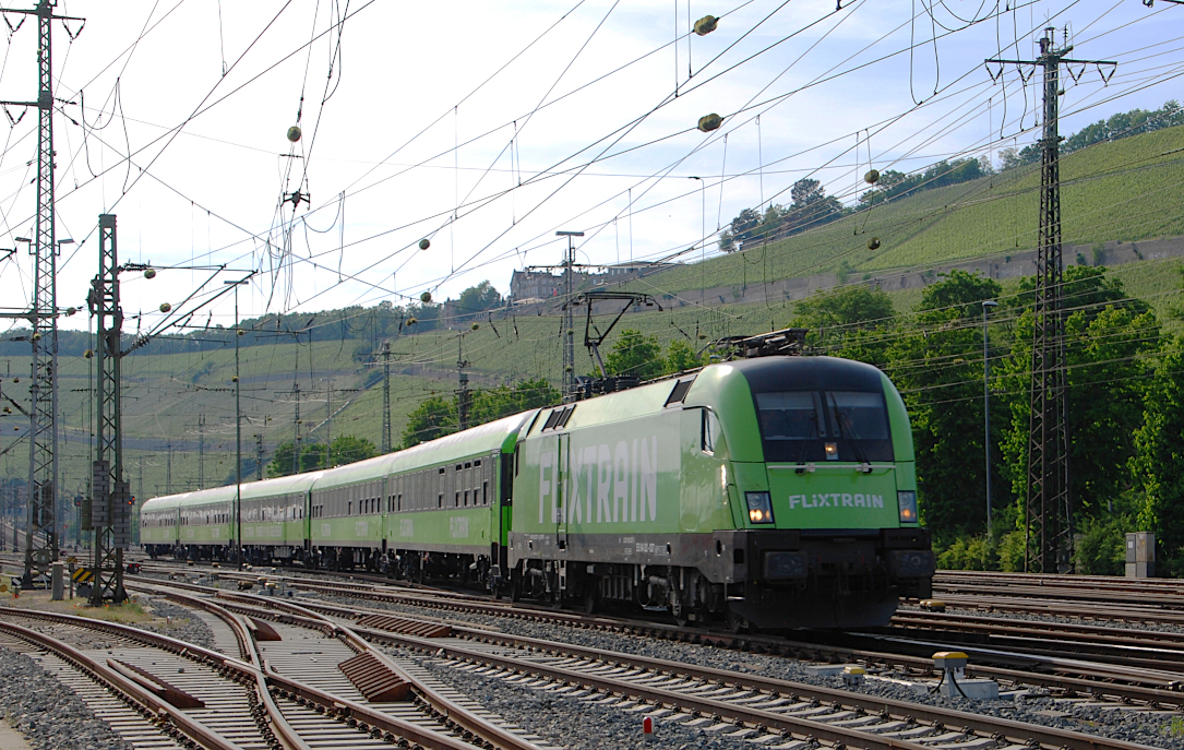 Zwei Tage vor der offiziellen Betriebsaufnahme der Flixtrain-Linie FLX25 fanden am Mittwoch, 16.06.2021, Probefahrten von München über Augsburg, Würzburg, Aschaffenburg, Hanau nach Frankfurt(Main) und zurück statt. Die Aufnahme zeigt den FLX25 (76333) bei der Rückfahrt mit Lok ES 64 U2-037 (182 537) und fünf bei Talbot in Aachen modernisierten ex-Interregiowagen pünktlich in den Würzburger Hbf rollen. Betreiber des Zugpaares ist die Internationale Gesellschaft für Eisenbahnverkehr (IGE).

