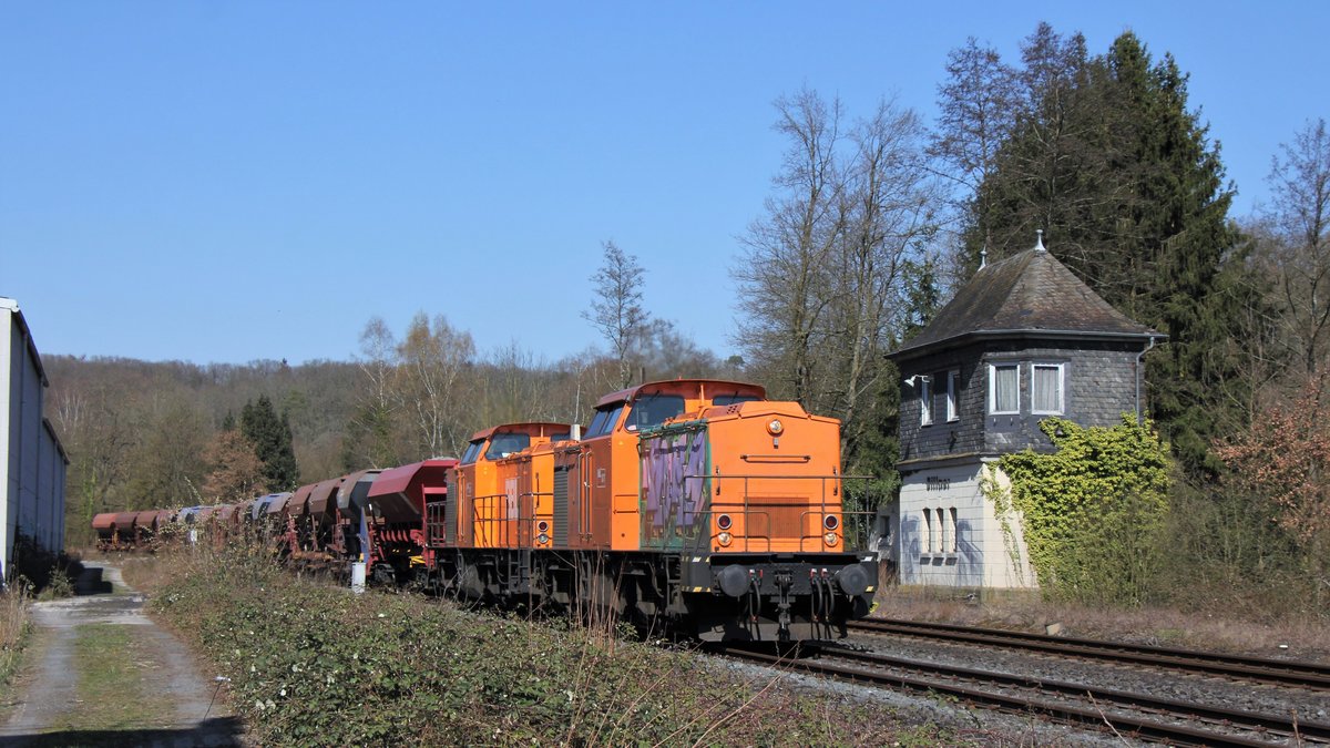 Zwei V 100 fahren einen Schotterzug über die Lahntalbahn am Mittwoch, den 25.03.2020 am alten Villmarer Weichenwärter-Stellwerk Vo vorbei.