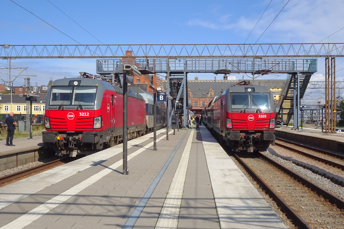 Zwei Vectron AC der DSB stehen mit Doppelstockzügen über Kopenhagen nach Roskilde im dänischen Bahnhof Helsingør bereit. Die Vectron haben 2023 beinahe den gesamten Zugverkehr zwischen Helsingør und Roskilde übernommen, das sind immerhin Werktags vier Zugpaare pro Stunde. Einzelne Kurse werden über Roskilde hinaus verlängert.
Der Bahnhof von Helsingør galt bei seiner Fertigstellung im Jahr 1890 als der schönste Bahnhof Dänemarks.
Helsingør, Freitag, 1. September 2023, 14.21 Uhr (Kamera zeigt Winterzeit.....)