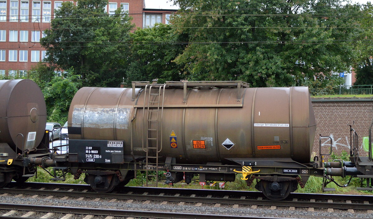 Zweiachsiger Kesselwagen vom Einsteller WASCISA AG mit der Nr. 23 RIV 80 D-WASCO 7475 230-0 Zces Befülling lt. UN-Nr.: 80/1824 = Natriumhydroxidlösungen (Natronlaugen) in einem gemischten Kesselwagenzug am 25.08.21 Hamburg-Harburg.  