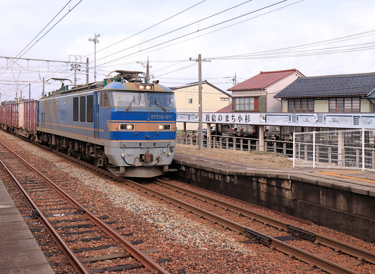 Zweistromloks Serie EF510-500: In den Jahren 2009 bis 2016 bauten die JR East Japan 15 eigene Loks hauptsächlich für Luxus- und Schlafwagenzüge in den hohen Norden. Zwei Loks (509/510) sind silbergrau, die anderen blau. 2015 bis 2017 wurden diese Loks von JR Freight für den Güterverkehr übernommen und verkehren, wie die anderen EF510, vor allem der Küste des Japanischen Meers entlang von Osaka und Kyoto nach Norden. Hier durchfährt EF 510-511 von JR Freight die Station Kosugi, die heute der privaten Ainokaze Toyama Bahn gehört. Der Bahnhof ist geschmückt mit einer Dekoration, die auf das traditionelle Handwerk des Verputzens von Hauswänden (Stuckatur) hinweist. 20.März 2024 