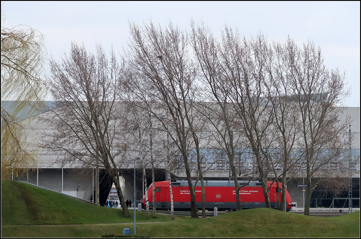 Zwischen Bäumen und Sichtbeton -

...eine rote E-Lok bei der Durchfahrt im Hauptbahnhof Wolfsburg.

Vielleicht eine nicht ganz gelungene Aufnahme, da die Lok doch etwa weiter rechts hätte sein dürfen, mit dem linken Fahrerhaus zwischen den beiden Birken. Leider hat meine Kompaktkamera kein Sucher und über Display ist es doch schwieriger den richtigen Moment zu sehen. Aber irgendwie gefallen mir die windschiefen Bäume, die rot dahinter hervorleuchtende Lok, vor dem graunen Phaneogebäude der Stararchitektin Zaha Hadid.

14.03.2017 (M)


