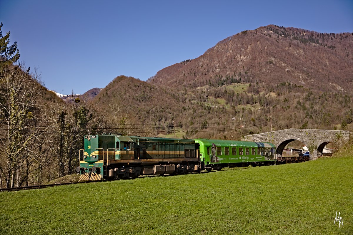 Zwischen Bohinjska Bistrica und Most na Soci (bzw. Podbrdo) pendeln Autotransportzüge, die wie hier mit der Baureihe 644 bespannt sind. Hier zu sehen die 644-020 zwischen Hudajuzna und Grahovo. (07.04.2018)