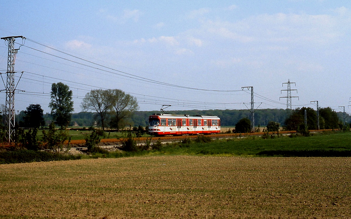 Zwischen Düsseldorf-Wittlaer und Duisburg-Kesselsberg fährt die frühere Linie D und heutige U 79 durch weitgehend landwirtschaftlich genutztes Gebiet, hier nähert sich ein GT8S der Rheinbahn im Sommer 1980 der Düsseldorf-Duisburger Stadtgrenze