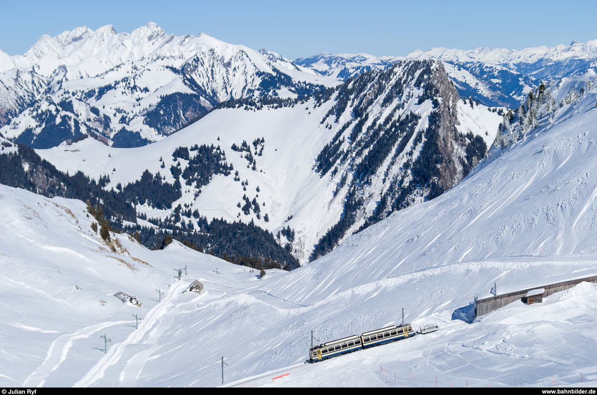 Zwischen der Haltestelle La Perche und der Bergstation Rochers-de-Naye befindet sich am 6. März 2015 der Bhe 4/8 301 auf Bergfahrt. Nach passieren der Galerie wird er in Kürze sein Ziel erreichen.