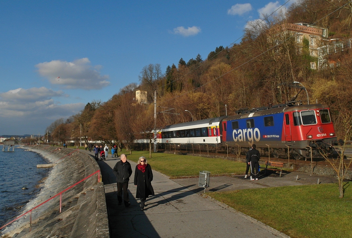 Zwischen Lochau und Bregenz führt die Bahnlinie parallel zur Uferpromenade des Bodensees entlang. Wenige Minuten nach der Übernahme der Wagen in Lindau befindet sich Re 421 379-9 mit dem EC 194, München - Zürich, hier am 25.01.2014 auf der Fahrt Richtung Zielbahnhof. Die Bregenzer sprechen bei diesem Uferabschnitt auch von der 'Pipeline', weil hier seit den 1960er-Jahren eine Ölpipeline verlief, die von Genua nach Ingolstadt führte. 1997 wurde die Pipeline stillgelegt.