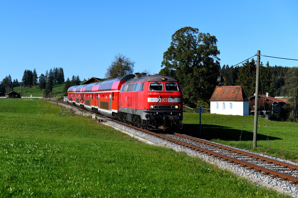 Zwischen Seeg und Weizen-Hopferau konnte ich am 14. Oktober 2018 die 218 446 mit ihrem RE 57510 auf der Fahrt nach Füssen aufnehmen. Rechts im Bild die Kapelle St. Sebastian in der Tannenmühle aus dem Jahr 1706. 