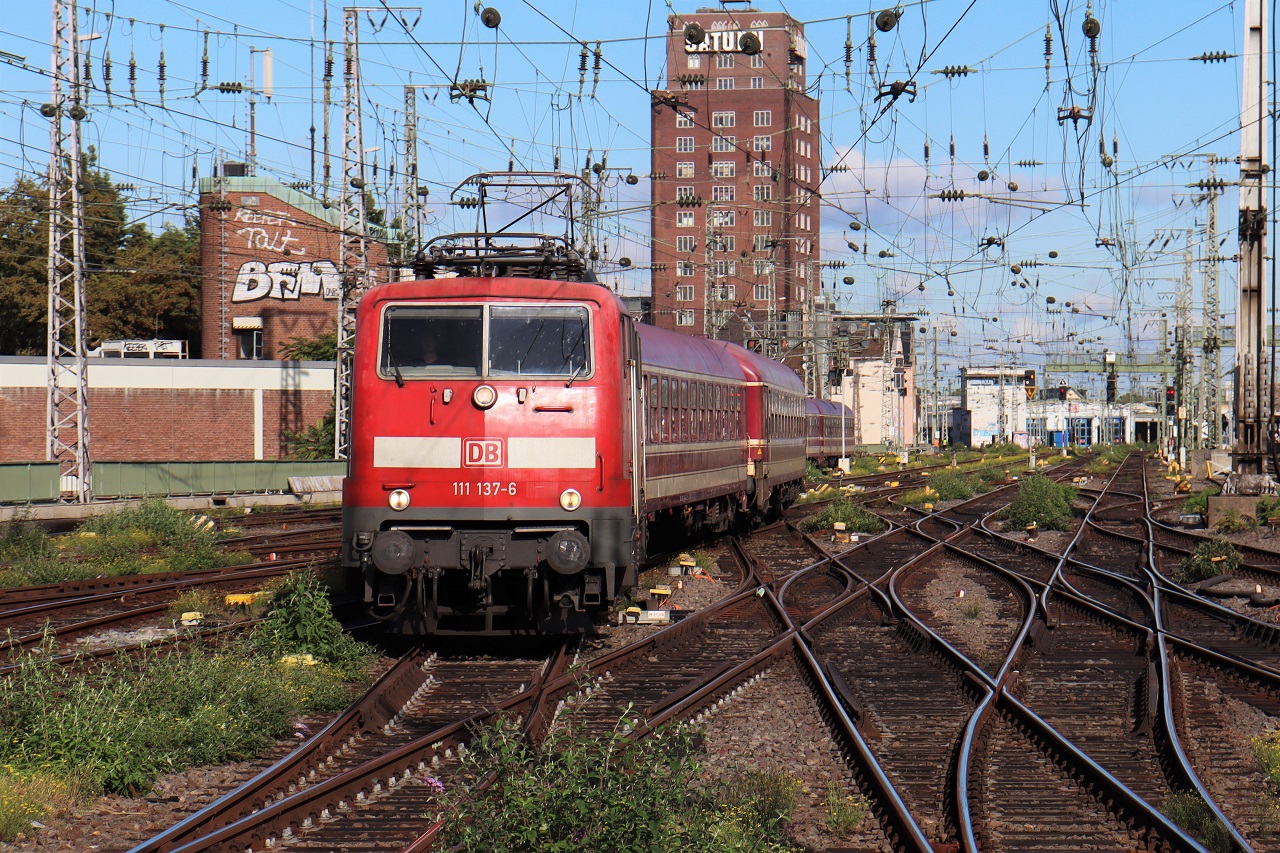 111 137 schlängelt sich mit dem TCS 26480 durch die Weichenstraßen vor dem Hbf Köln. Aufnahme entstanden vom Bahnsteigende Gleis 6/7. 