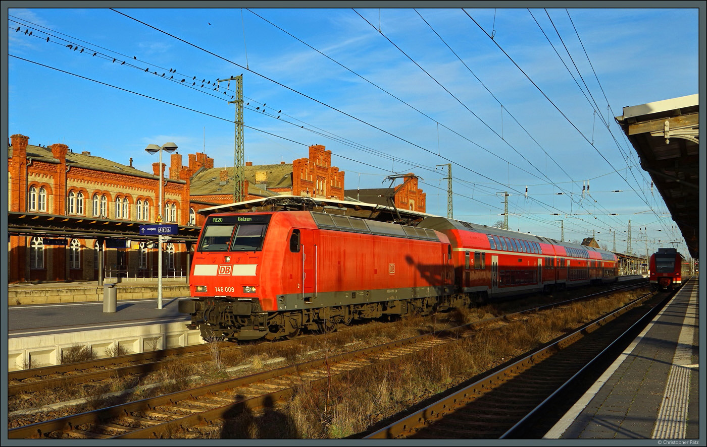 146 009 verlässt mit dem RE 20 nach Uelzen am 05.02.2023 Stendal Hbf. Rechts daneben steht im Schatten des Bahnsteigdachs ein 425 als RB 32, welcher die kleineren Stationen bis Salzwedel bedient.