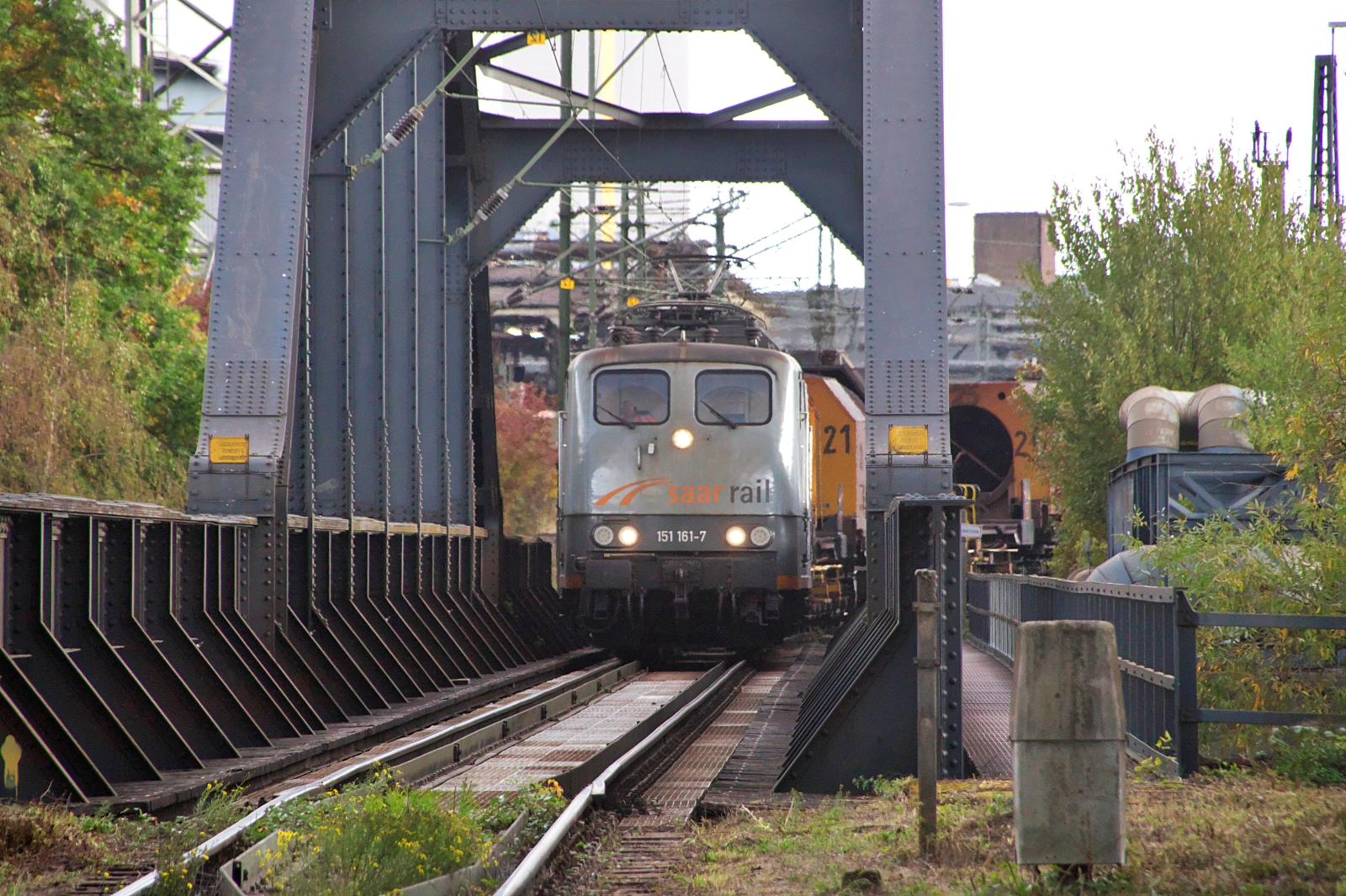 151 161-7 zieht den  Suppenzug  auf die Saarbr�cke zwischen dem Bahnhof V�lklingen und dem Stadtteil Wehrden. Die Bisttalbahn (Strecke 3290) wird noch auf zwei Kilometern als Ausziehgleis von Saarstahl benutzt. 11.10.2026
