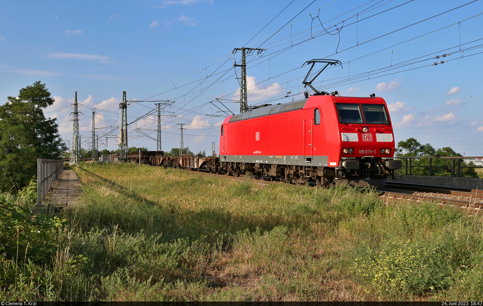 185 079-1 überquert mit leeren Containertragwagen die Leipziger Chaussee (B 6) Richtung Abzweig Halle Thüringer Bahn.

🧰 DB Cargo
🕓 24.6.2023 | 18:47 Uhr