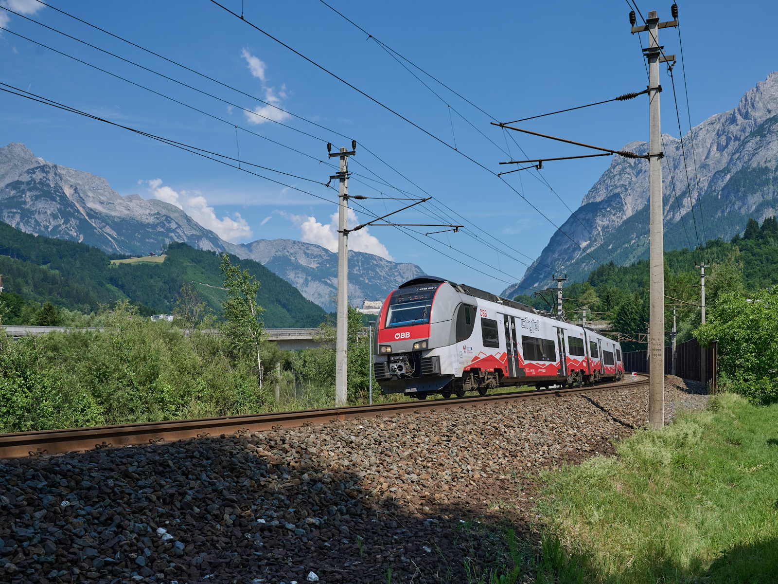 4748 022 war am 21.06.2026 als R 1510 auf dem Weg von Salzburg nach Saalfelden. Zwischen Werfen und Pfarrwerfen haben die Fahrg�ste einen herrlichen Ausblick auf das Hagen- und Tennengebirge sowie die dazwischen liegen Festung Hohenwerfen.