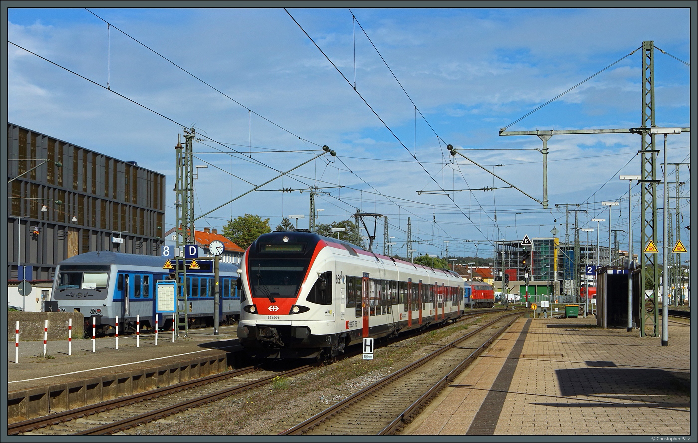 521 204 der SBB erreicht am 07.10.2023 den Bahnhof Singen (Hohentwiel). Links wartet der  Freizeitexpress Südbahn  der SVG auf die Rückfahrt.