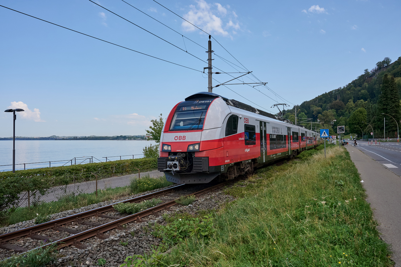 Am Ufer des Bodensees entlang f�hrt die Bahnstrecke von Lindau nach Bregenz. Neben zahlreichen Regionalz�gen und S-Bahnen kommen internationale Fern- und G�terz�ge. Am 08.09.2026 war 4748 019 als R25965 auf dem Weg von Lindau nach Bludenz und durchf�hrt in K�rze den Bregenzer Hafenbahnhof.