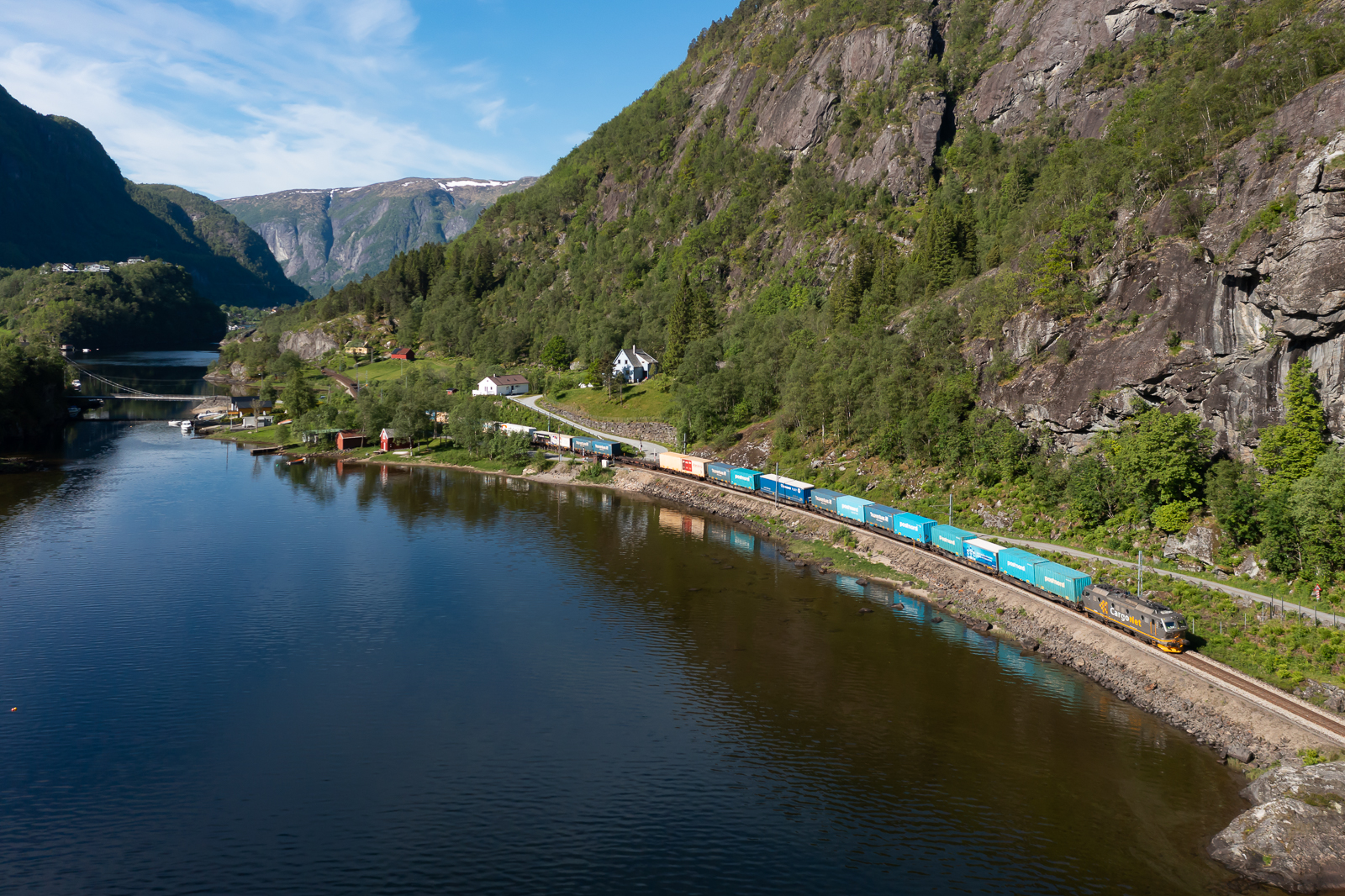Am Vormittag des 07.06.2022 ist Güterzug 5506 von Cargonet bei Stanghelle auf dem Weg in Richtung Oslo. Neben Lebensmitteln wird vorallem die Post auf der Bahn transportiert.
