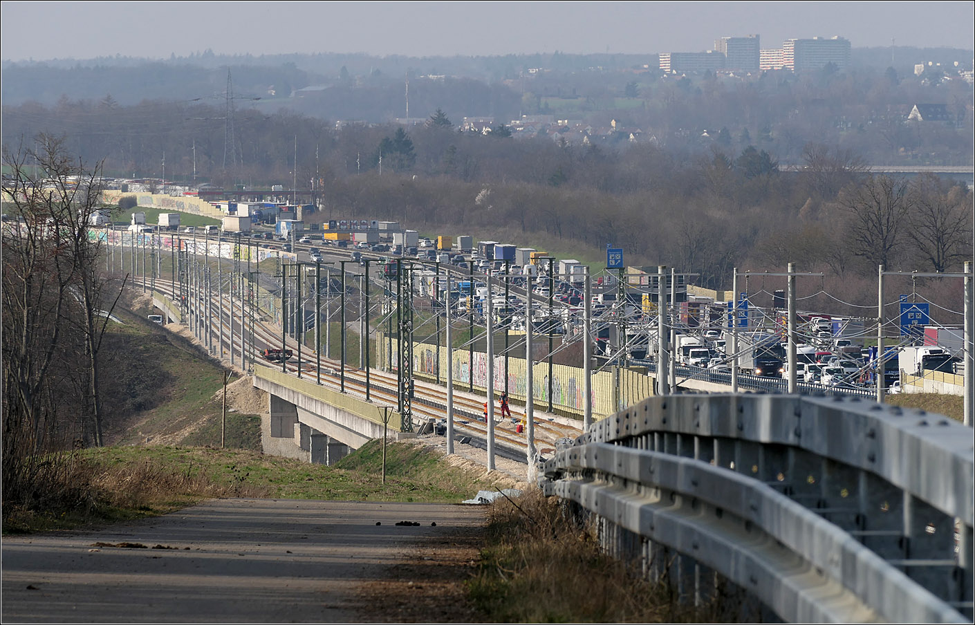 An der Autobahn entlang - 

Die noch nicht ganz fertige Schnellfahrstrecke zwischen Stuttgart und Ulm bei Köngen. Dichter Verkehr herrscht auf der parallel verlaufenden Autobahn A8. Die parallele Führung zweier Hauptverkehrswege wird auch Bündelungstrasse genannt um nicht zweimal die Landschaft zu durchschneiden. Links der Bildmitte ist das Sulzbachviadukt zu erkennen. Weiter hinten ist dann auch noch die Brücke über das Denkendorfer Tal zu sehen.

29.02.2024 (M)