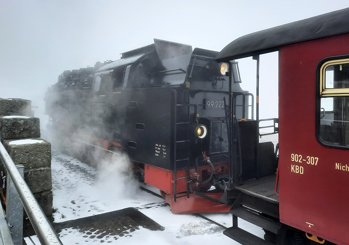 Ankunft in der verschneiten Bergstation Brocken. Die Lok wartet in Nebel zum Umsetzen. Brocken, 17.4.2024