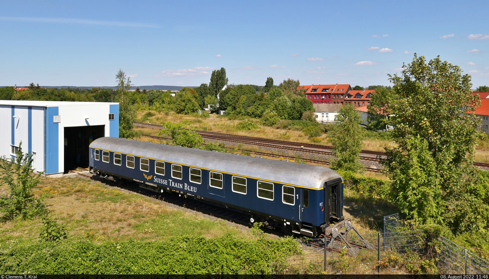 Bei der Verkehrs Industrie Systeme GmbH (VIS) Halberstadt ist ein UIC-X-Wagen (DB) mit der Bezeichnung  Am  (A4ümg-54 | 56 80 10-40 360-4 D-IRSI), womöglich zur Aufarbeitung, abgestellt. Er soll bei Sonderzugfahrten des Suisse Train Bleu in der Schweiz zum Einsatz kommen.
Fotografiert von der Magdeburger Chaussee (B 81).

🧰 Suisse Train Bleu (Rail Event AG)
🕓 8.8.2022 | 11:48 Uhr