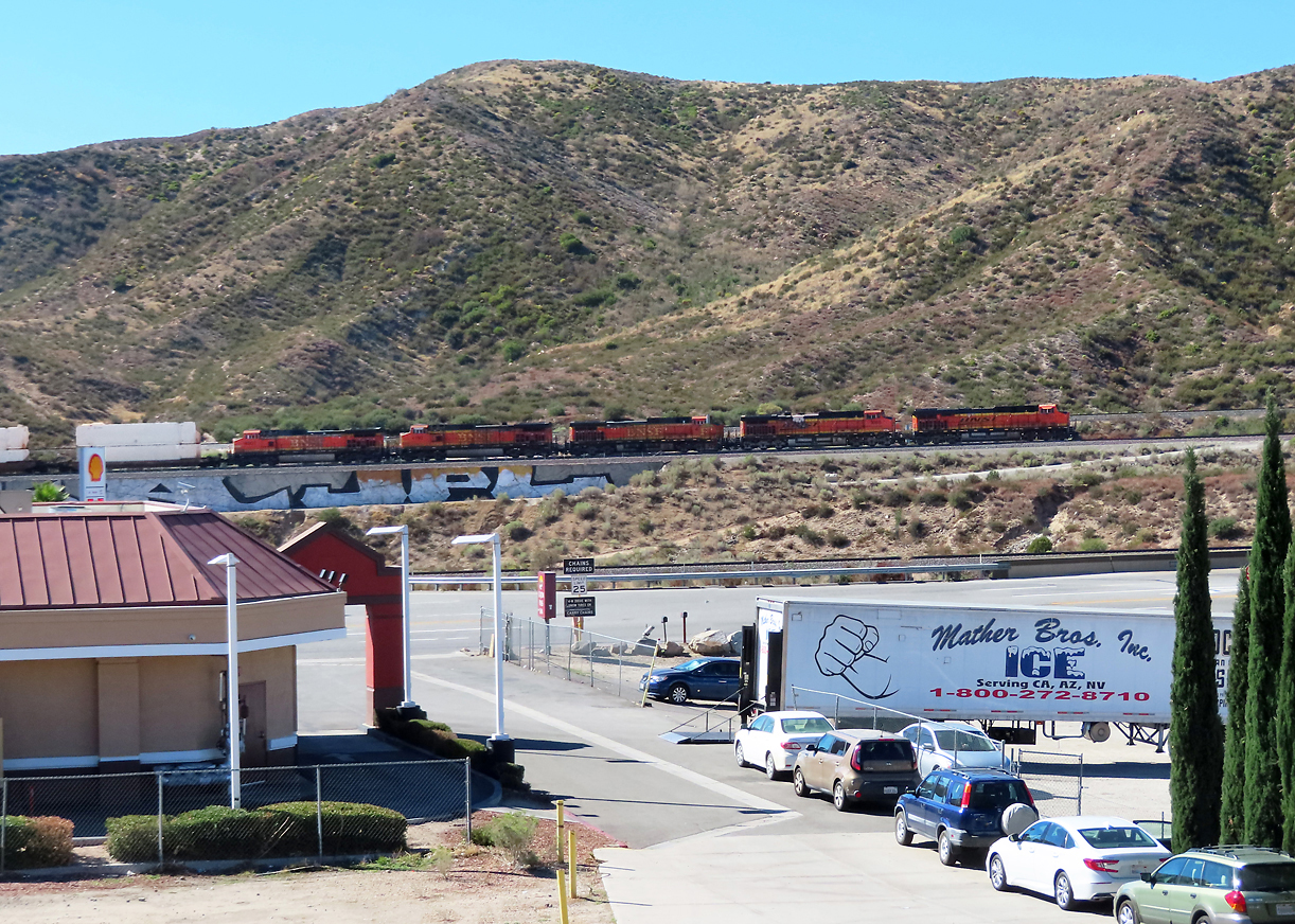 Blick von unserem Hotel in 'Cajon Junction' (so heisst der 'Ort' bei der Autobahn-Ausfahrt) in Richtung Bahngleise auf dem südlichen Teil des Cajon Passes. An dieser Stelle gibt es drei verschiedene Gleise, der bergwärts fahrende Güterzug befindet sich auf dem mittleren Gleis. Cajon Pass, CA, 24.9.2022