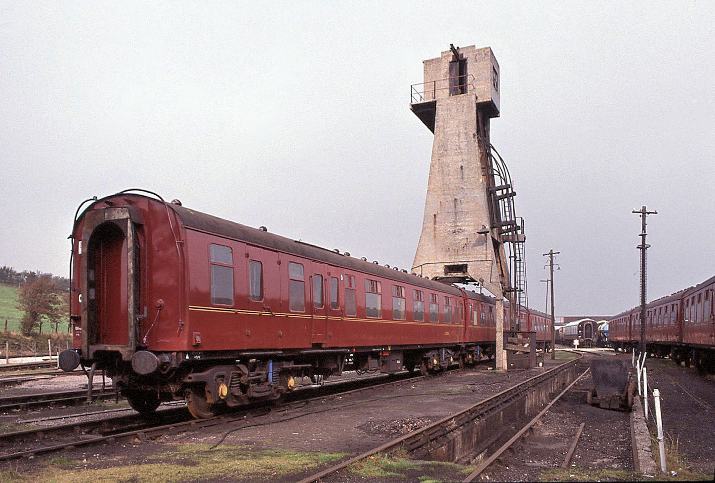 Britische Personenwagen: Ein klassischer Wagen Mark I (etwa 1963 gebaut) in der lange Zeit typischen kastanienroten Farbgebung. Als Nr. 99304 ist der Wagen bei der Gesellschaft für Sonderfahrten West Coast Railways eingereiht. Aufnahme im Areal der Eisenbahnsammlung Carnforth, öffentlich zugänglich bei Bezahlung von Eintritt. Im Hintergrund die Bekohlungsanlage für Dampfloks. 12.Oktober 1991  