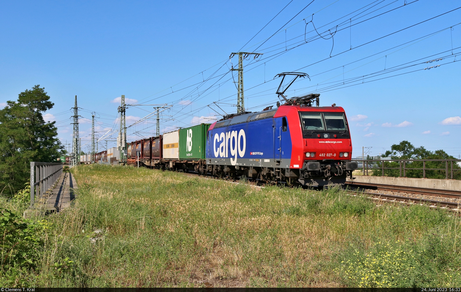 Containerzug (Bertschi AG) mit Re 482 027-0 überquert in Halle (Saale) die Leipziger Chaussee (B 6) Richtung Abzweig Thüringer Bahn.

🧰 SBB Cargo AG, vermietet an die SBB Cargo International AG
🕓 24.6.2023 | 16:33 Uhr