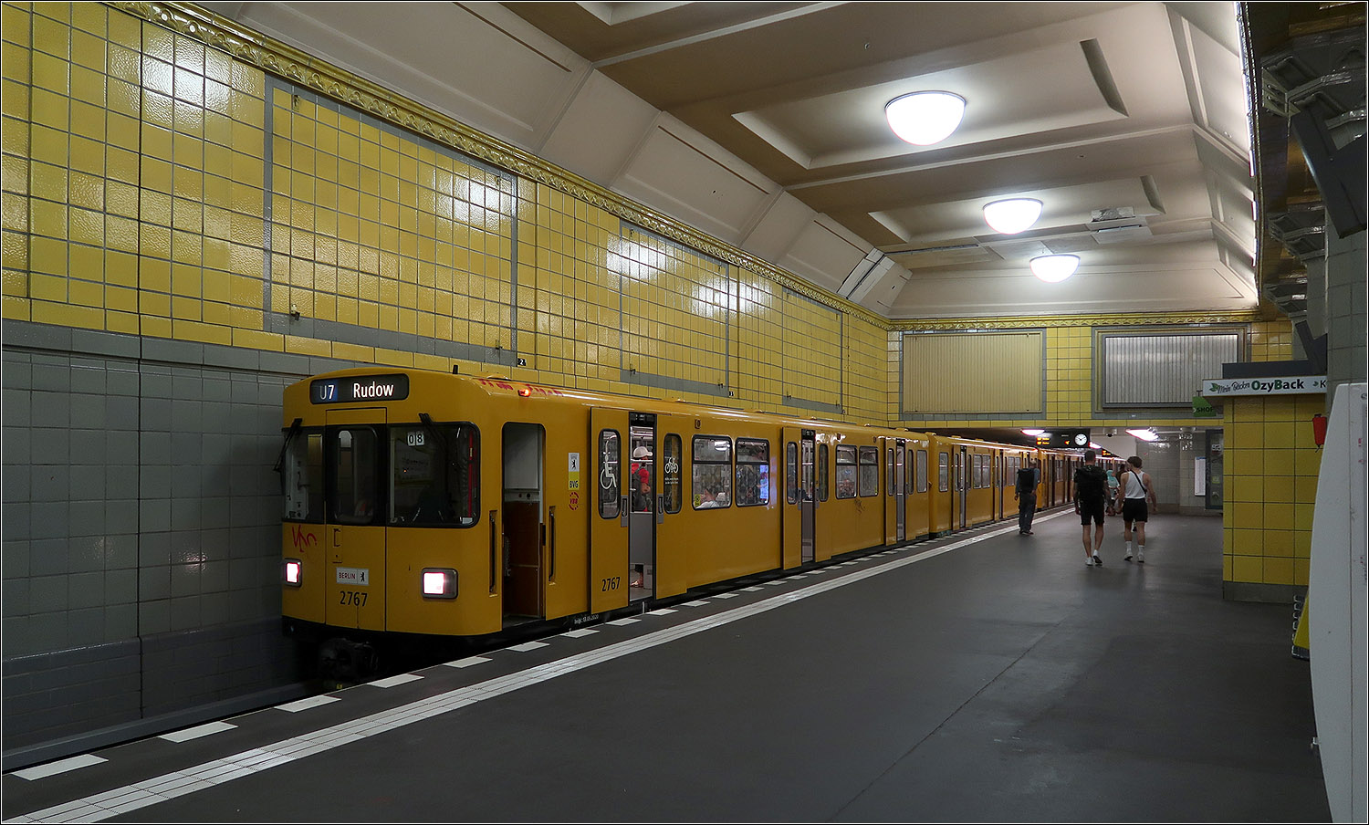 Da wo sich U7 und U8 kreuzen - 

U-Bahnhof Hermannplatz in Berlin-Neukölln. In dem 1926 eröffneten unteren Stationsteil der Umsteigehaltestelle fährt heute die U7. Der obere Bahnsteig (heute U8) wurde 1927 eröffnet und kreuzt den unteren Bahnsteig etwa in der Mitte. Der obere Bahnsteig teilt die hohe Halle der unteren Ebene in zwei Teile. Hinter der Wand die hinten im Bild das Gleis und den Bahnsteig quert fährt und hält die U8. Diese Querung wurde mittels einer Stahlfachwerkkonstruktion baulich gelöst. Direkte Treppen verbinden beide Bahnsteige auf kürzestem Weg.

Es wurde auch untersucht die Gleise der beiden Linien nebeneinander zu legen um wie am U-Bahnhof Mehringdamm einen direkten Umstieg in gleicher Richtung am Bahnsteig gegenüber zu ermöglichen. Dies hätte aber für die jetzige U8 enge Gleisradien vor und nach der Station erfordert, um die Gleise parallel zu den der U7 zu bringen.

Die hohe Halle der U7-Ebene am Hermannplatz gehört zu den eindrücklichsten Bahnhofshallen der Berliner U-Bahn.

15.07.2023 (M)