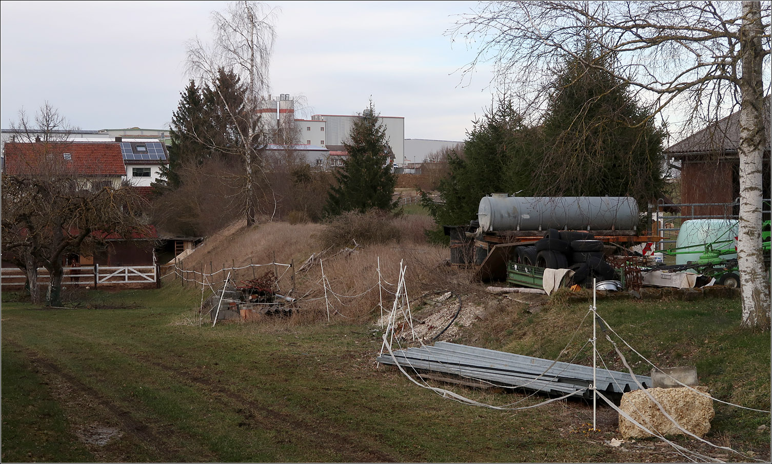 Das Albbähnle - Auf Spurensuche in Merklingen - 

Nördlich des einstigen Bahnüberganges der Scharenstetter Straße liegt die ehemalige Trasse des Bähnle im Privatbereich der dortigen landwirtschaftlichen Betriebe. Der Wassertank steht quer zu dem einstigen Gleis. In Bildmitte ist dann gut der ehemalige Bahndamm zu erkennen. Die Strecke machte ab hier in Richtung Autobahn einen sanften Bogen nach Nordosten. Im weiteren Verlauf ist sie heute teilweise durch neue Gewerbebetrieb überbaut.

Der Haltepunkt Merklingen Ost dürfte auf der Südseite der Scharenstetter Straße gelegen haben.

17.03.2023 (M)