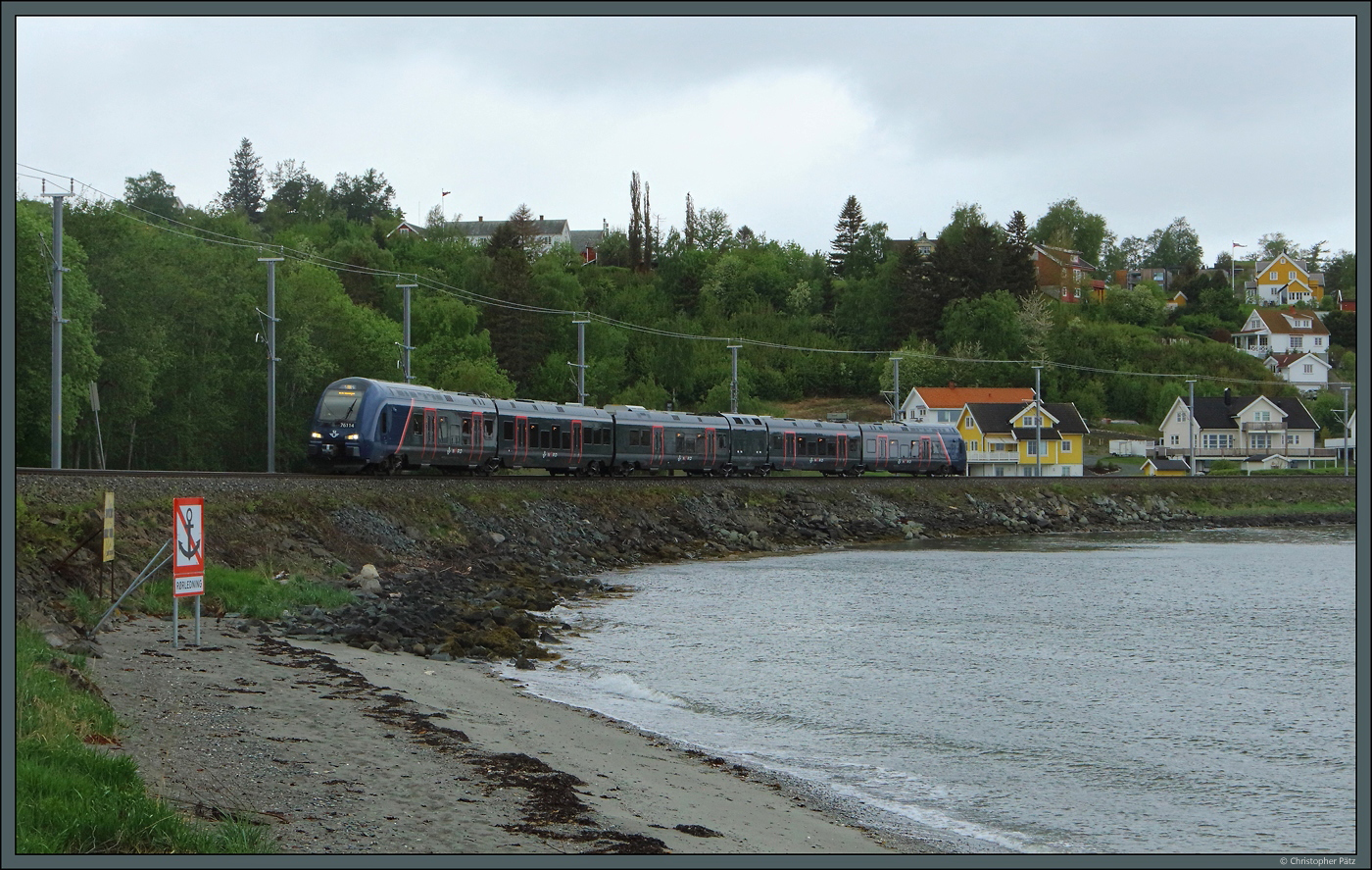 Das Trondheimer S-Bahn-Netz wird derzeit schrittweise elektrifiziert. Zum Einsatz kommen Dual-Mode-Triebwagen der Baureihe 76. 76114 der SJ Nord fährt am 25.05.2023 an der Küste bei Vikhammer mit Diesel entlang. Die neuen Oberleitungsmasten stehen bereits, aber noch fehlt der Fahrdraht.