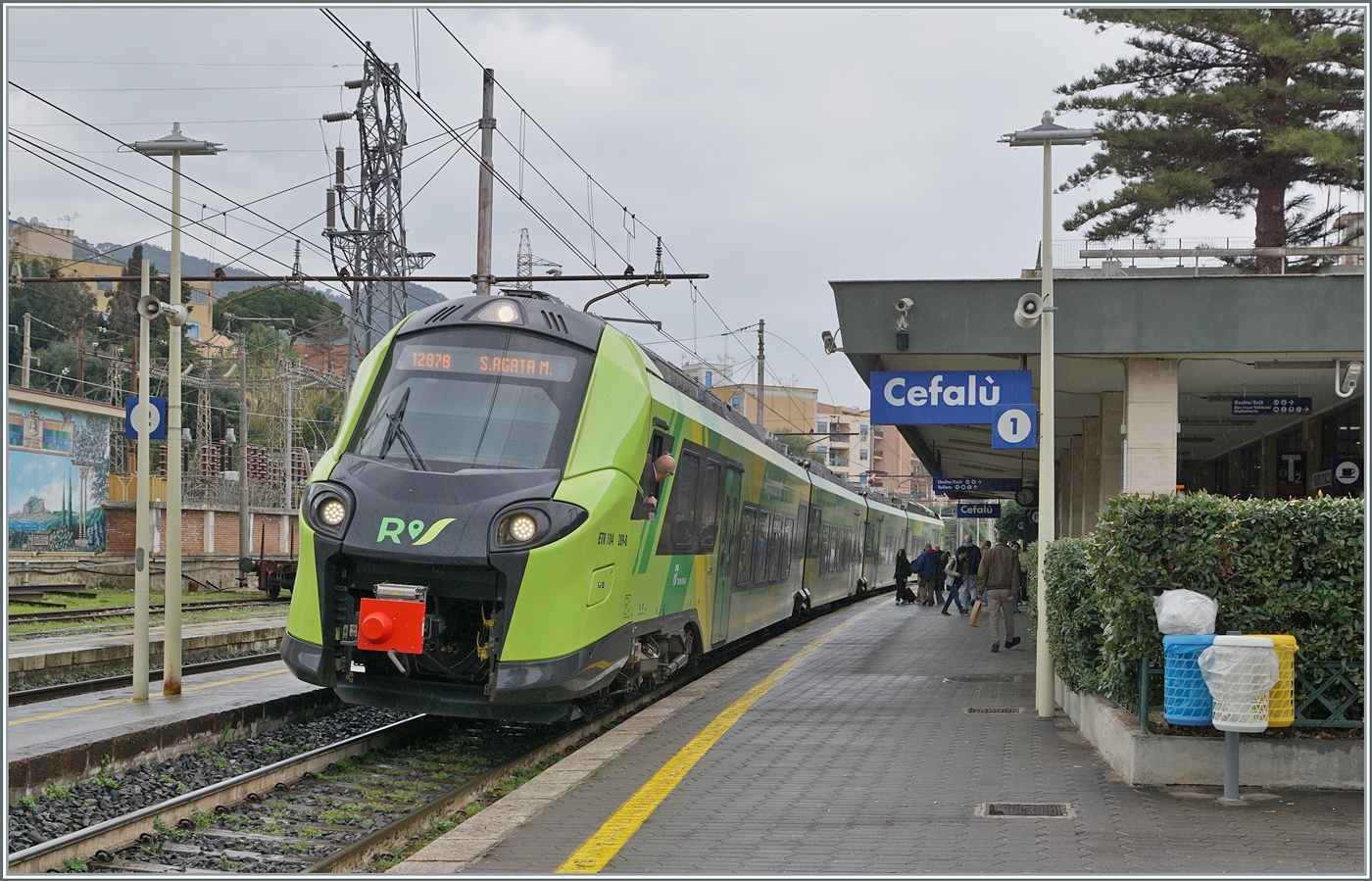 Der FS Trenitalia ETR 104 289 ist als R 12878 von Palermo nach San Agata Militello unterwegs und wird nach dem kurzen Halt in Cefalù gleich weiterfahren. 
Das Bild zeigt auch ansatzweise, dass in Cefalù die weiteren Geleise über recht schmale Bahnsteige erreicht werden. Zudem endet von Palermo kommend kurz vor Cefalù die Doppelspur.  

6. März 2026