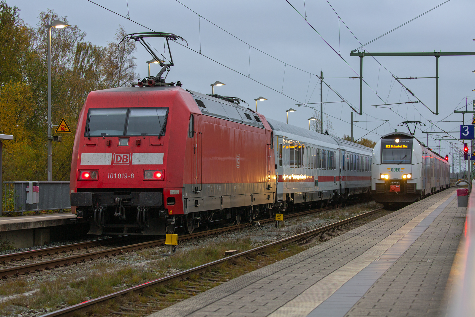 Der zum Ausfahrsignal vorgezogene IC mit einer Lok der BR 101 kreuzt in Bergen auf Rügen mit  dem ODEG Triebwagen 4746 305. - 11.11.2022 - 
Am frühen Abend diente das Geländer des Bahnsteig’s 3 als Stativ.