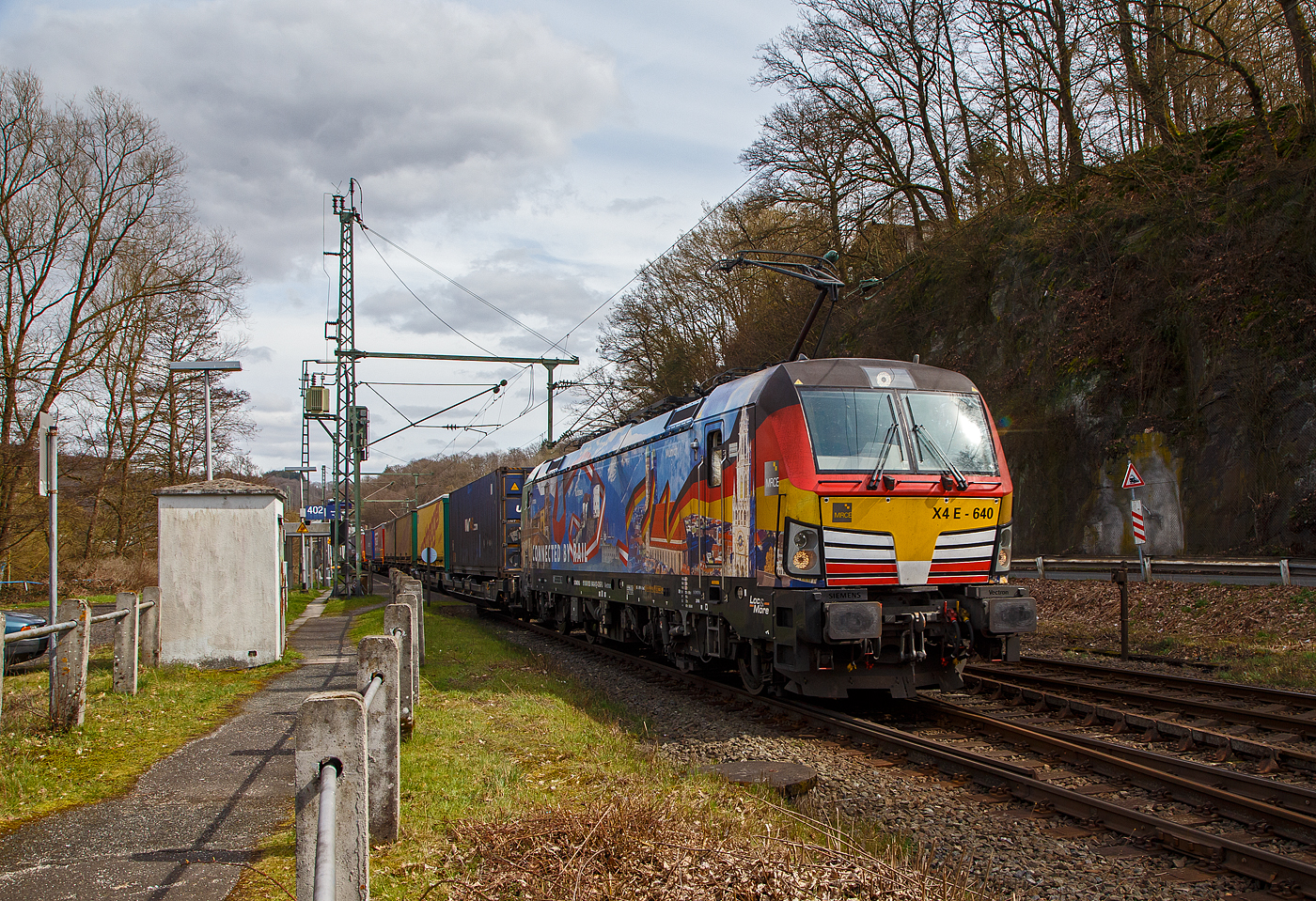 Die bunte und schöne an die TX Logistik AG vermietete Siemens Vectron MS X 4 E – 640 / 193 640-0 “Connected by Rail” (91 80 6193 640-0 D-DISPO) der MRCE Dispolok GmbH (München) fährt am 28.03.2023, mit einem KLV-Zug, durch Scheuerfeld (Sieg) Richtung Köln. 

Die Siemens Vectron MS - 6.4 MW wurde 2016 von Siemens in München-Allach unter der Fabriknummer 22164 gebaut. Sie hat die Zulassungen für Deutschland, Österreich und Italien, daher trägt sie auch die Werbung München, Kufstein, Verona (Connected by Rail). Sie hat eine Höchstgeschwindigkeit von 160 km/h.