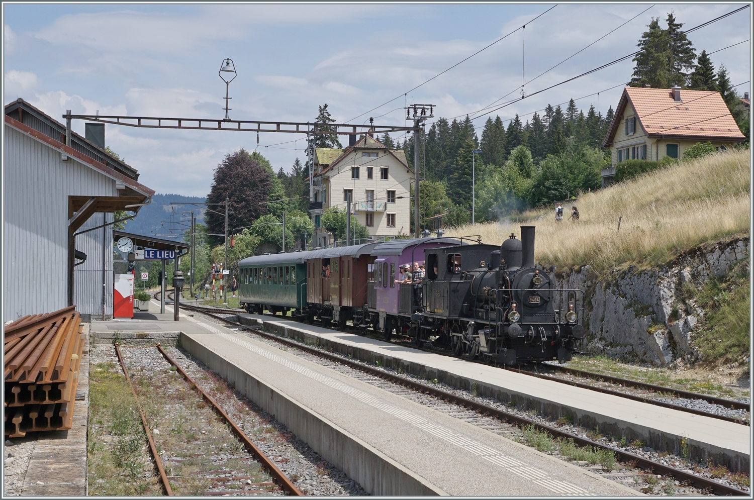 Die E 3/3 8494  Tigerli  (UIC 90 85 0008 494-6) mit ihrem Zug nach Le Brassus erreicht den Bahnhof von Le Lieu, wo es eine Kreuzung mit der S4 (Le Brassus - Aigle) abzuwarten gilt.

23. Juli 2023