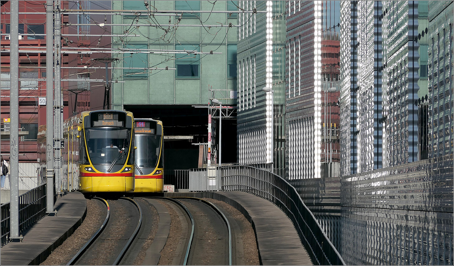 Die erste Neubaustrecke in Basel nach 65 Jahren -

... war im Jahr 2001 die Verbindung vom Centralbahnplatz zur Münstensteinerbrücke, die zu einem Großteil als Viadukt mit einer Haltestelle neben den SBB-Gleisen verläuft. Dadurch wurde es möglich die BLT-Linien 10 und 11 über den SBB-Bahnhof zu führen.

Hier begegnen sich zwei Stadler Tango-Bahnen an der Haltestelle Peter Merian.

18.09.2025 (M)


